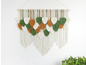 Detail of woven leaf patterns on macrame wall hanging with cotton ropes and wood