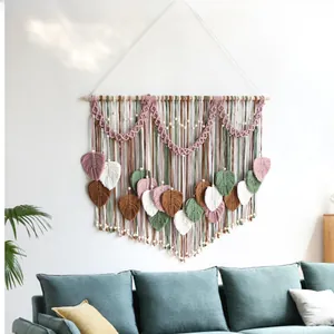 Close-up of handmade macrame wall hanging with colorful woven leaves and wooden beads