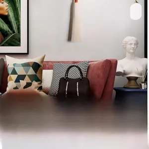 Dark brown handbag with silver vertical stripes displayed on a pink fabric sofa