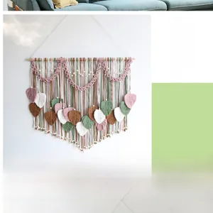Detail view of handcrafted macrame wall hanging with multi-color leaf patterns and wooden pole