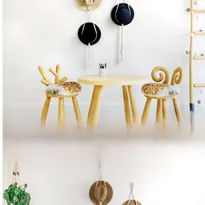 Detailed view of child's wooden table and chairs with animal-shaped velvet backrests