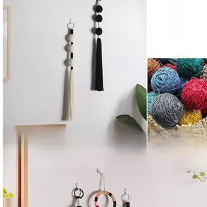 Detailed close-up of handmade bohemian woven wall hanging with tassels and spheres