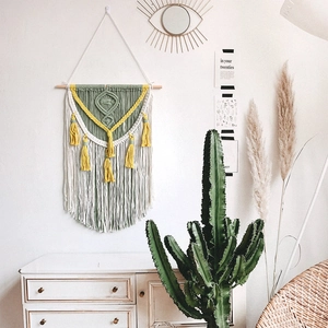 Handwoven bohemian macrame wall hanging with yellow tassels in sage green and cream