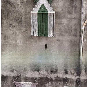 Dettaglio di arazzo in macramè fatto a mano con frange di cotone in verde e viola