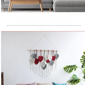 Detailed handmade macrame wall hanging with woven leaf tassels in red, grey, and cream colors