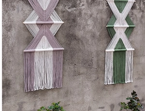 Dettaglio di arazzo in macramè fatto a mano con tessitura di cotone viola e verde e frange