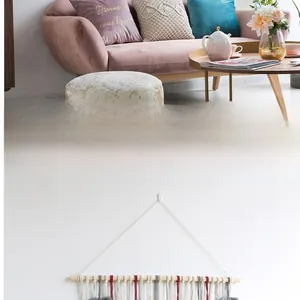 Detail of macrame wall hanging with leaf fringe on wooden pole for bohemian home decor