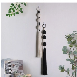 Detail of handmade woven ball tassel wall hangings in minimalist black and white style