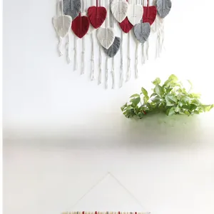 Close-up of bohemian hand-woven cotton leaf tassels in red, white and grey tones