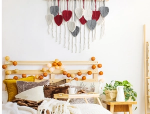 Detail of bohemian macramé leaf wall hanging with red and grey cotton rope fringe
