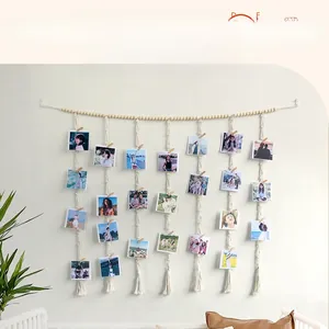 Detail of bohemian handmade woven fringe tapestry with wooden clips and photos