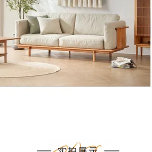 Close-up of cream fabric sofa cushions and natural wood armrest in a bright living room