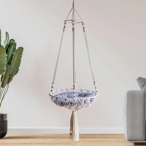 Detail of bohemian handwoven cotton rope cat hammock with tassels and purple velvet cushion