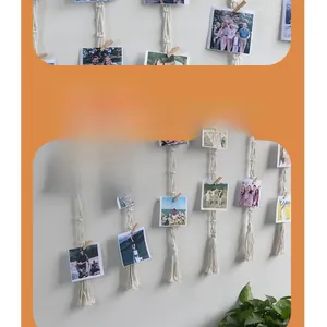 Detail of bohemian handmade woven cotton wall tapestry with wooden clips for photos