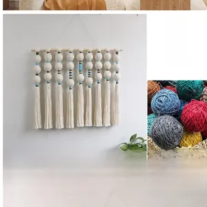 Hand-woven wall tapestry featuring white tassels and decorative circular yarn balls