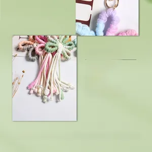 Detail of handmade woven flower keychain with soft cotton rope and pearl decoration