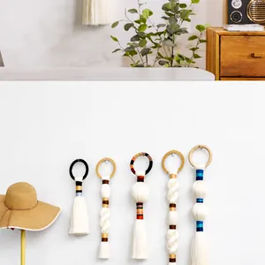 Detailed view of handmade woven cotton tassel wall hangings with colorful thread accents