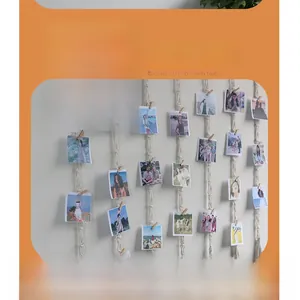 Detail of woven boho photo hanging wall decor with clips and white cotton rope tassels