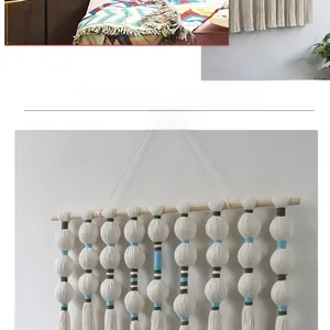 Macro detail of hand-woven wall hanging with white tassels and colorful thread spheres