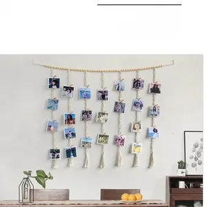 Detail of macrame photo wall hanging with wooden beads, clips and handmade cotton tassels