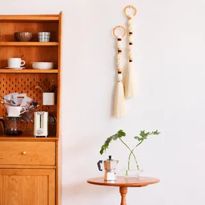 Detail of Nordic woven macrame wall hanging with wooden rings and tassel fringe decor