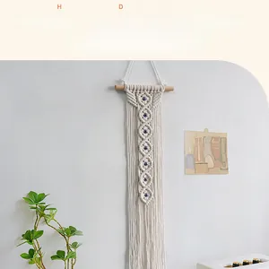 Detail of bohemian handmade cotton rope wall hanging with evil eye beads and fringes