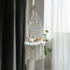 Close-up of handmade cotton rope weave cat hammock with decorative tassels and plush cushion