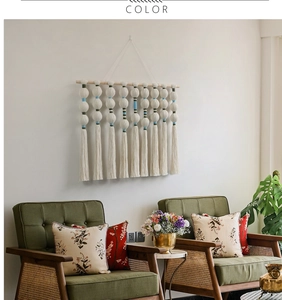 Detail view of Bohemian macrame wall hanging with white cotton ropes and spherical tassels