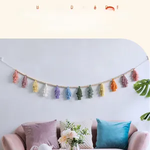 Detail of colorful cotton tassels and wooden beads on a Nordic style wall hanging