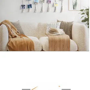 Detail of cream fabric sofa with camel blanket and geometric knit pillows for home decor