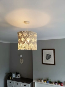Détail d'abat-jour en macramé fait main avec franges et éclairage chaleureux doux