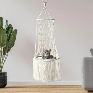 Handmade macrame cat hammock with fringe and cushion in a modern home setting