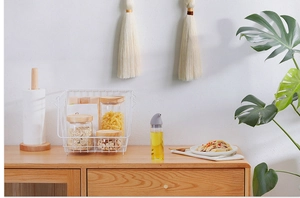 Detail of glass oil dispenser and storage jars in a Nordic style kitchen setting
