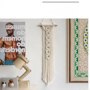 Detail of Boho hand-woven cotton tapestry featuring blue evil eye beads for wall decor