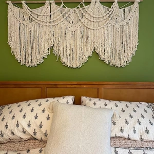 Detailed macro view of bohemian hand-woven cotton macrame wall hanging with layered tassels