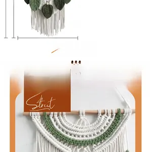 Dettaglio di arazzo in macramè fatto a mano con foglie verde scuro e nappe in corda di cotone