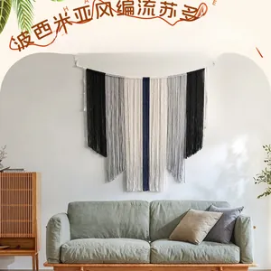 Détail d'une tenture murale bohème faite main avec des glands en coton multicolores