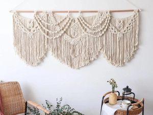 Detail of handcrafted bohemian macrame wall hanging with geometric woven patterns and fringe