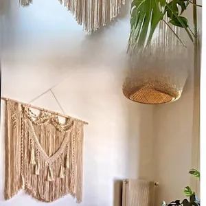 Detailed view of hand-woven macrame wall hanging with cotton tassels and wooden rod