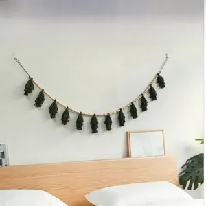 Detail of Nordic wooden bead wall hanging with green layered tassels in a bedroom setting