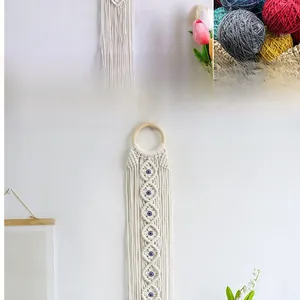 Detailed close-up of handmade boho macrame wall hanging with blue evil eye beads and tassels