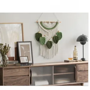 Dettaglio nappe a foglia su arazzo boho fatto a mano con trame di corda in puro cotone