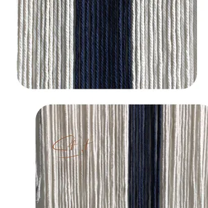 Détail macro d'une tapisserie en coton tissée main avec glands bleu marine et crème style nordique