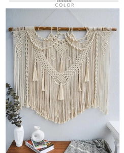 Detail of bohemian handmade cotton woven tapestry with wooden dowel and elegant tassels