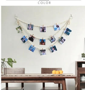 Detail of bohemian wall photo display with 3-tier woven cotton ropes and 12 wood clips