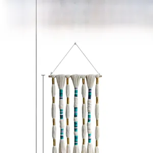 Detailed view of handmade bohemian wall tapestry with blue and gold woven threads