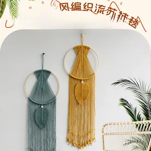 Detail of handmade macrame wall hangings with leaf patterns and tassels in mustard and grey