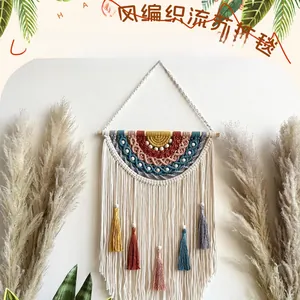Detail of bohemian handmade woven tapestry with colorful tassels and wooden beads