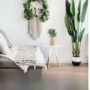 Detailed macro view of handmade macrame fox wall hanging with greenery and cotton tassels