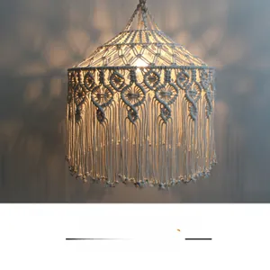 Detail of bohemian hand-woven cotton lamp shade with intricate macrame patterns and fringes